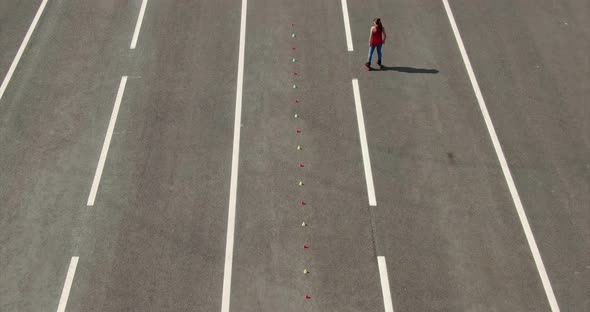 Woman Athlete Rides on Roller Skates Makes a Figure Eight By Kicking alt