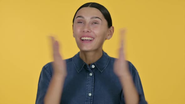 Excited Latin Woman Celebrating Yellow Background alt