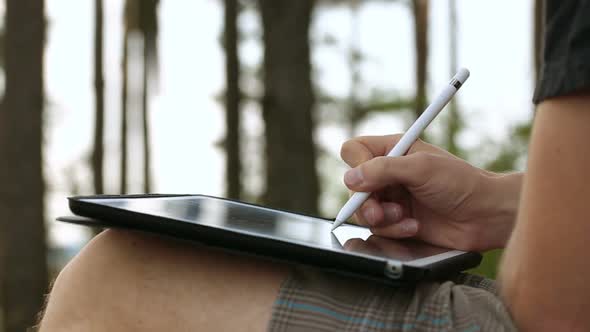 Designer Drawing and Scaling On Tablet Using Stylus on Nature