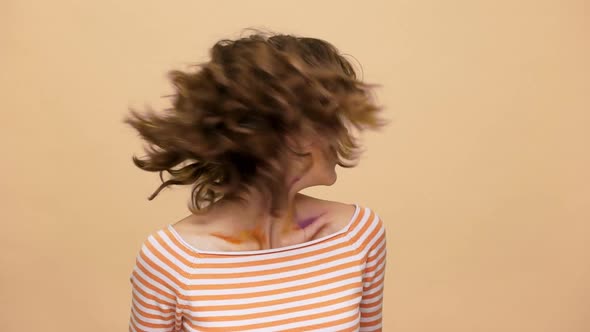Portrait of Joyful Female Artist Admiring Her Colorful Drawing on Face and Waving Head with Floating alt