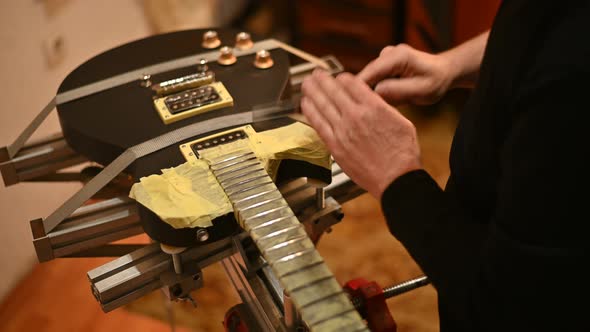 Guitar in repair service shop with a hands of a guitar luthier