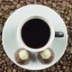Chocolate Candy And A Cup Of Black Coffee On A Background Of Rotating Coffee Beans. - VideoHive Item for Sale