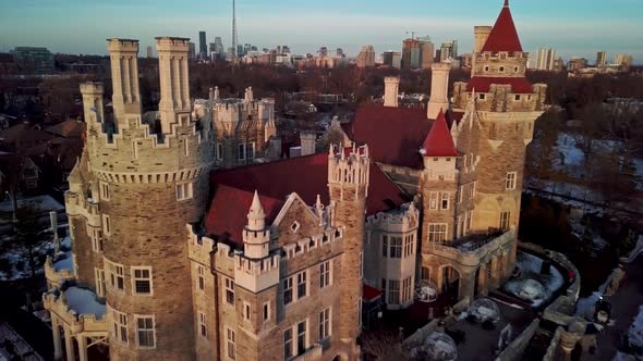 Flying over the Turrets and Red Tile Roof of a Castle at Golden Hour. Drone shot of Casa Loma Touris alt