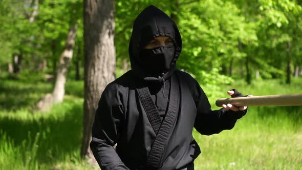 Portrait of a Ninja Man. Japanese Ninja in a Black Suit Is Training in Nature alt