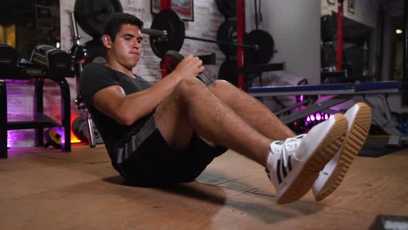 Young Man Performing Abdominal Exercises with Weights