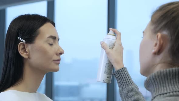 The Makeup Artist Uses a Spray to Finish Her Makeup and Gently Sprays It on Her Client