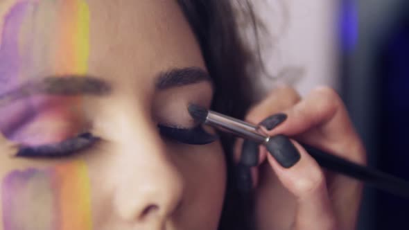 Closeup View of Makeup Artist Makes Models Eye Makeup with False Eyelashes alt