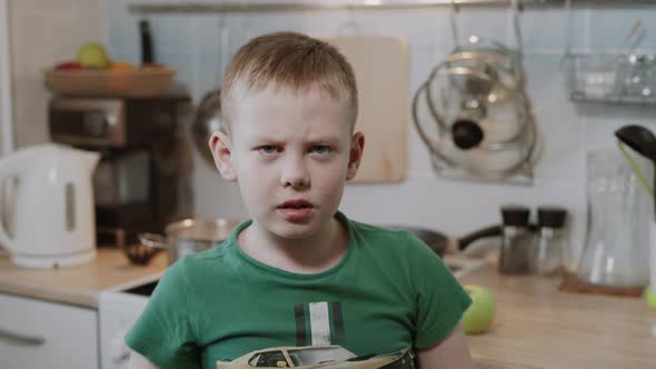 Caucasian Boy is Angry Nervous and Waves His Hands at the Camera in Kitchen alt