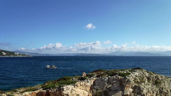 Fishing boat sailing with seagulls flying around. alt