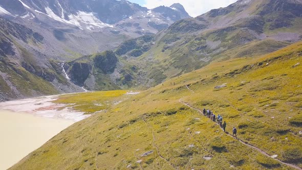 Group of tourists hiking in mountains alt