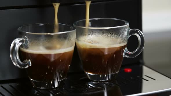 Coffee From the Coffee Machine Is Poured Into Glass Cups