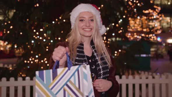 Young lady hands you present and is excited to see your reaction alt