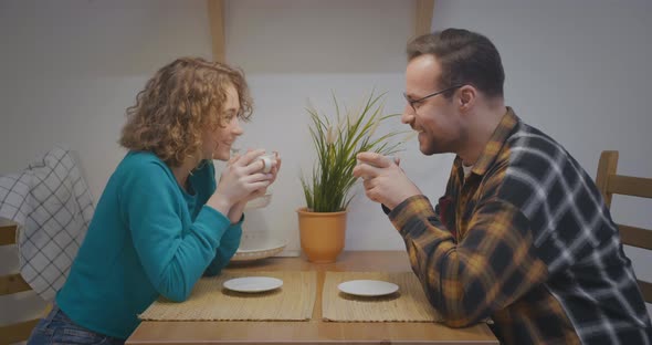 Loving Couple Communicating at Kitchen Holding Coffee Cups alt