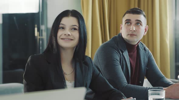 Office Workers Look at the TV Screen and Watch Closely alt