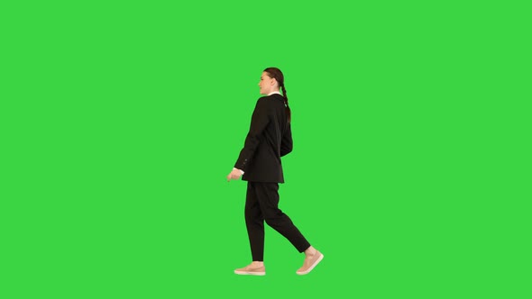 Young Woman in Office Suit Walking Like a Model Raising Hands on a Green Screen Chroma Key alt