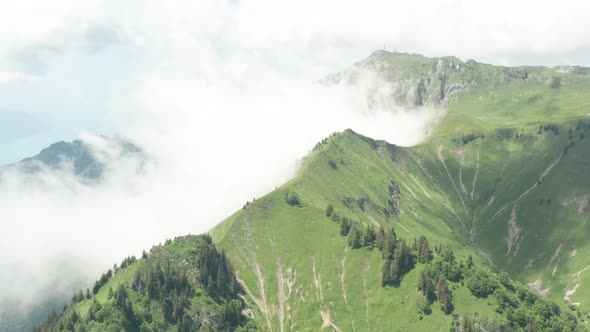 High angle view of white clouds colliding with green mountain tops alt