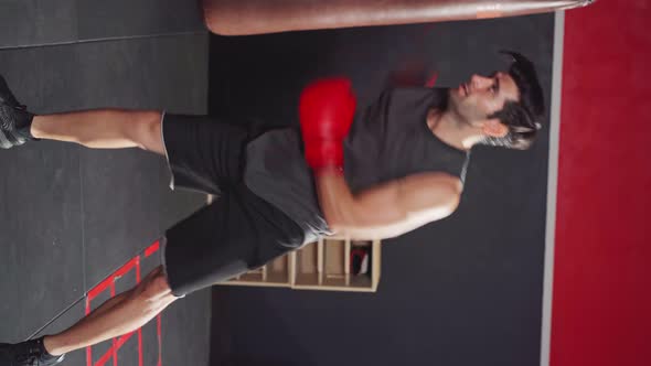 Vertical shot of active Caucasian sportsman workout, exercise doing boxing or Muay Thai. alt