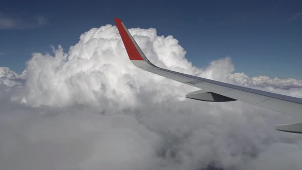 Airplane Wing Flies Past a Cloud