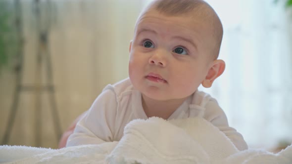 A Newborn Baby Lies Satisfied and Happy Playing with Positive Emotions alt