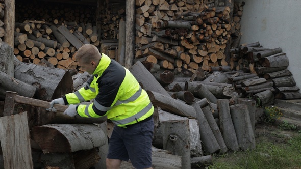 Lumberjack in Reflective Jacket. Man Woodcutter Hold Huge Axe Show Ok Sign. Sawn Logs, Firewood alt