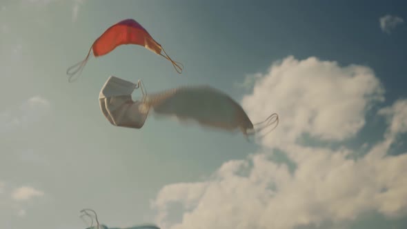 Throws up medical protective masks up in blue sky. Freedom from Coronavirus disease concept. alt