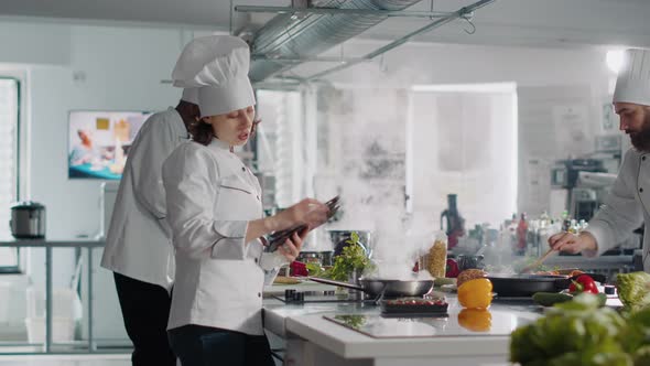 Female Chef Cooking Culinary Food Recipe From Digital Tablet alt