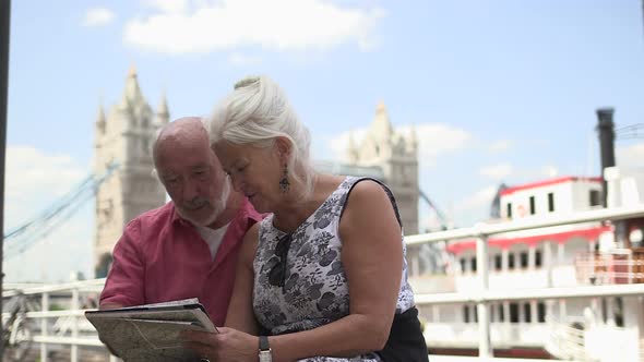 Senior couple standing in front of tower bridge, London, UK