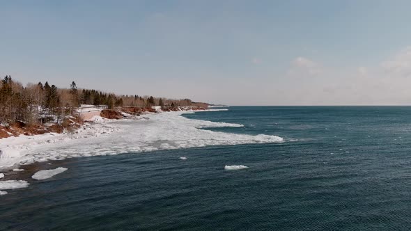 Frozen Coast And Calm Ocean Waters Of Duluth Minnesota in Winter - aerial shot alt