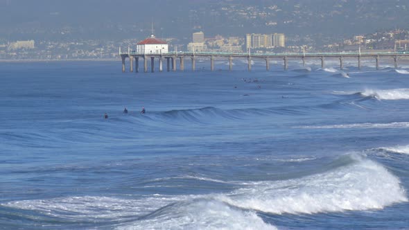 The Manhattan Beach Pier stands majestic over the Pacific Ocean. alt