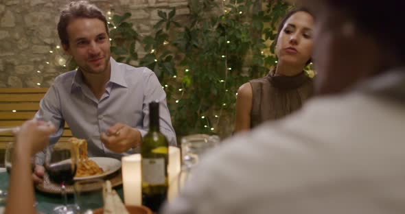 Four People, Two Couples Happy Talking and Eating During a Romantic Gourmet Dinner or lunch.Wide alt