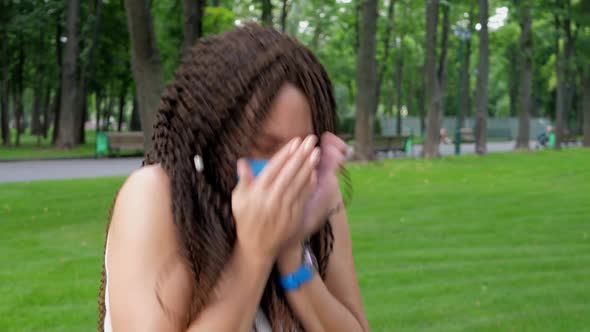 Young Adult Woman in Protective Mask Sneeze in Public Place Outside