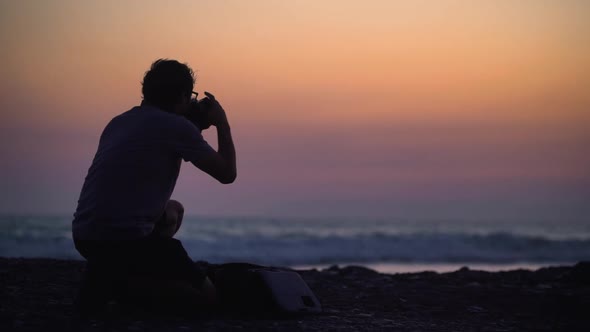 Silhouette of Photographer Taking Photos of Beach Against Sunset Sky