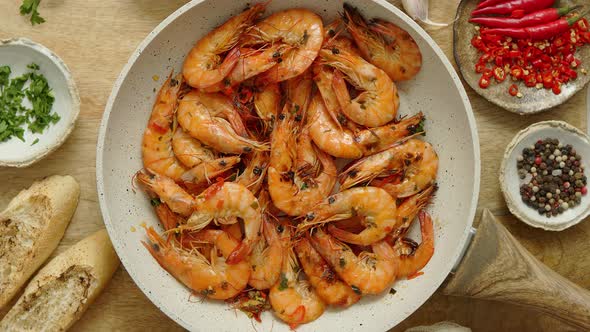 Roasted Prawns on Frying Pan Served on White Wooden Cutting Board alt