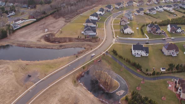 Aerial Drone Shot Tracking White Car Driving Through Suburban Neighborhood