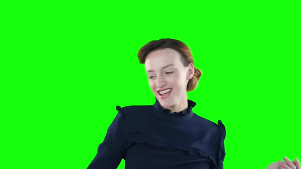 Happy Caucasian woman dancing on green background