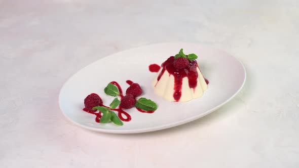 Woman's Hand Sprinkled with Crushed Pistachios Panna Cotta with Raspberry and Mint
