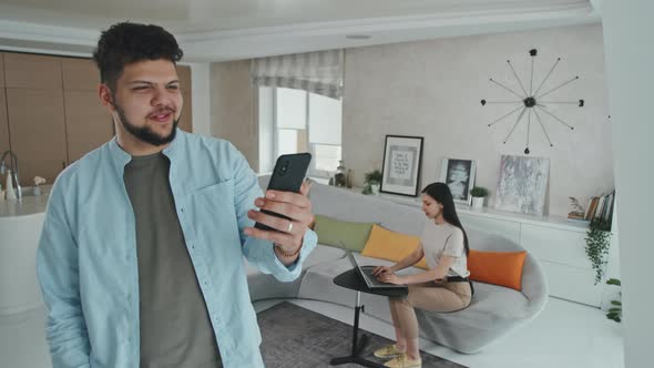Latin Man Video Calling On Smartphone At Home alt