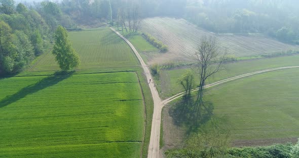 Moving Forward Over Gravel Paths and Green Fields in Summer Day alt