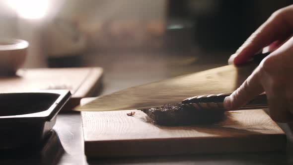 Restaurant Cooking  Chef Cutting a Piece of Meat with a Knife on the Board alt