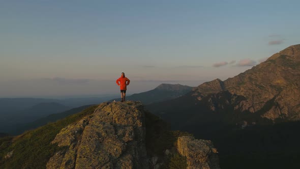 Single Hiker on Rocky View Point Above Deep Green Valley Looking the Sunset alt