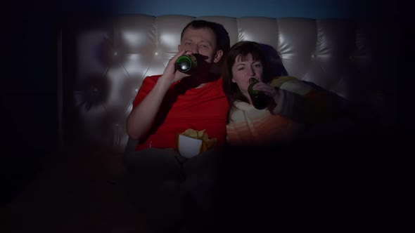 Couple Spend Time Together in the Evening Near the Tv Man and Woman Lie on the Bed Watching Tv Drink