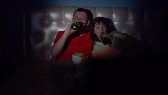 Couple Spend Time Together in the Evening Near the Tv Man and Woman Lie on the Bed Watching Tv Drink alt