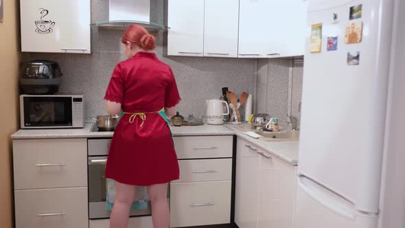 Housewife with Red Hair Cooks Food and Talks to Husband alt