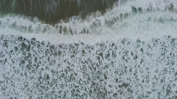 Aerial view of waves crash to beach slow motion video