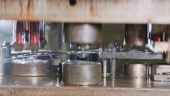 Close up of a punch press forming metal parts in a production line alt