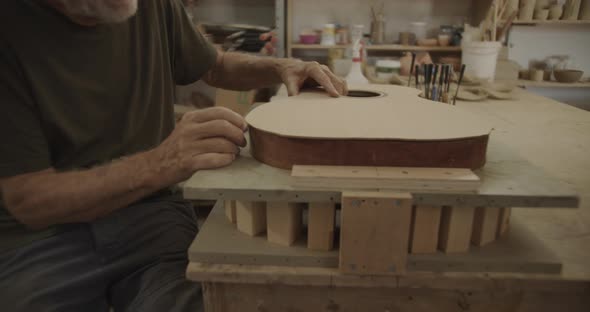 Luthier measures a guitar top part