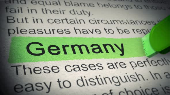 Germany. Highlighter pen marks word in Newspaper. Closeup. Thumbing pages and promoting text with ma alt