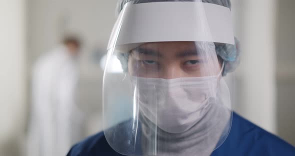 Portrait of Male Medical Doctor Wearing Protective Mask and Face Shield alt