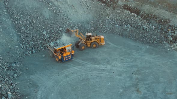 Excavator on the iron ore opencast, Loading of iron ore on very big dump-body truck alt