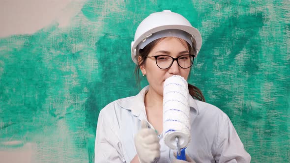 Joyful Designer in Helmet Shirt Gloves Sings Into Roller alt